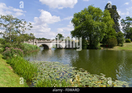 A three arched stone bridge going over the lake at Compton Verney House, Warwickshire, UK Stock Photo