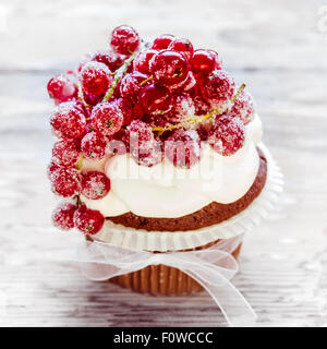 Sugared redcurrants on top of chocolate cupcake. Selective focus Stock Photo