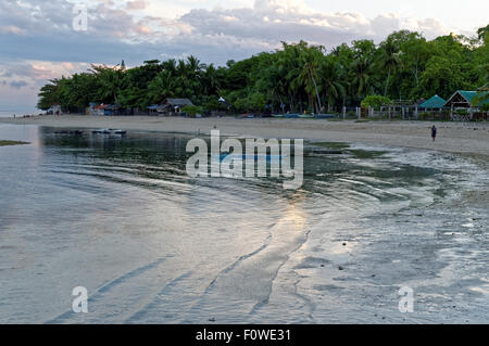 Early Morning Walk On the Shore. The sea water has receded and the sun is coming up Stock Photo
