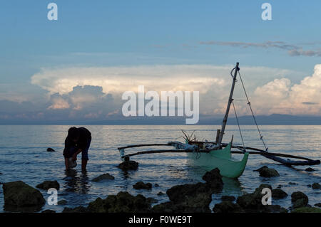 An Empty Fishing Boat On the Rocks. The fisherman came home after a fishing trip with inadequate catch Stock Photo