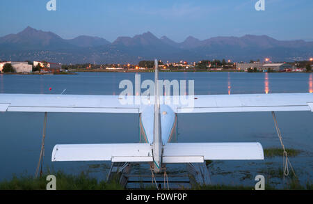 A plane sits waiting for the next chance to be of service as darkness falls on Anchorage Stock Photo