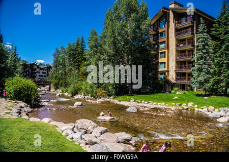 Gore Creek In Vail Colorado during summer with kids playing in stream Stock Photo