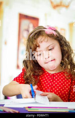 Sweet little girl using scissors Stock Photo