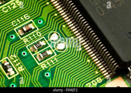 Circuit board components closeup showing conductive traces, chip contacts, and resistors Stock Photo