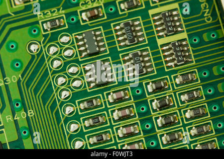 Circuit board components closeup showing conductive traces, micro IC chips, micor transistors, and micro resistors Stock Photo