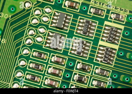 Circuit board components closeup showing conductive traces, micro IC chips, micor transistors, and micro resistors Stock Photo