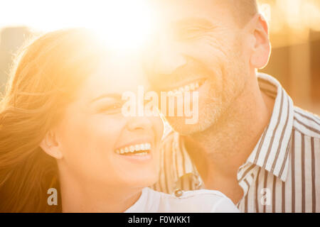 Happy couple having great time together - photographed at sunset against sun Stock Photo