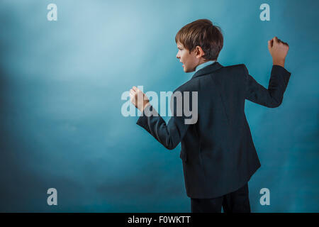 Teen boy clenched his fists fights businessman standing in profi Stock Photo