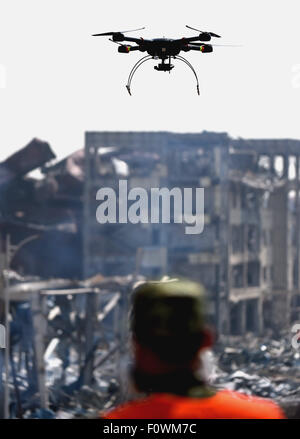 Tianjin, China. 22nd Aug, 2015. A rescuer using a drone detects the core blast site in Tianjin, north China, Aug. 22, 2015. Chemical-hazard experts have sped up the cleanup operation at the core area of the Tianjin warehouse blasts. Credit:  Zhang Chenlin/Xinhua/Alamy Live News Stock Photo