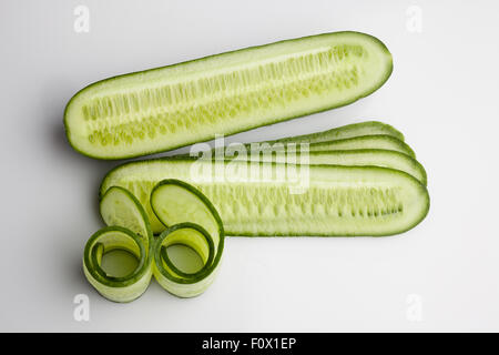 Sliced and rolled fresh cucumber on white background from above Stock Photo