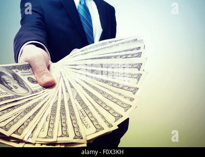 Business Man Displaying a Spread of Cash in Vintage Light Stock Photo