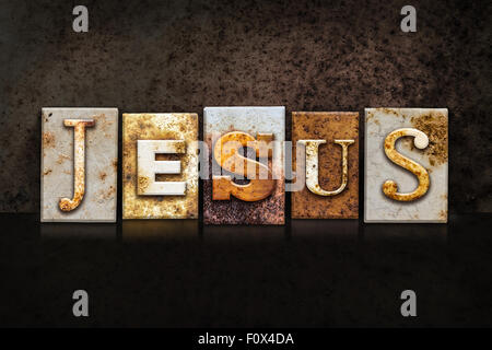 The name 'JESUS' written in rusty metal letterpress type on a dark textured grunge background. Stock Photo