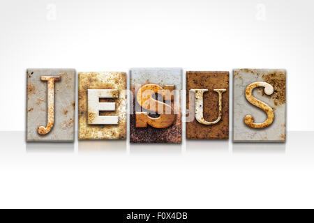 The name 'JESUS' written in rusty metal letterpress type isolated on a white background. Stock Photo