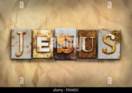 The name 'JESUS' written in rusty metal letterpress type on a crumbled aged paper background. Stock Photo