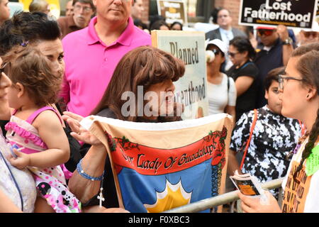 New York City, United States. 22nd Aug, 2015. Marietta Canning of Staten Island Right to Life League with religious banner during anti-abortion protest. A coalition of anti-abortion protesters protested on Mott Street in Manhattan in front of Planned Parenthood. Credit:  Andy Katz/Pacific Press/Alamy Live News Stock Photo