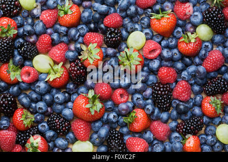 Blackberries, Grapes, Strawberries, Raspberries and Blueberries on a wooden tray. Stock Photo