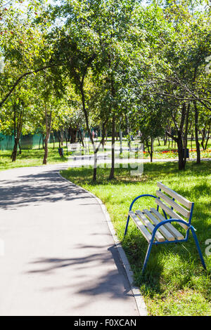 empty bench and walkway in urban public garden in summer day Stock Photo