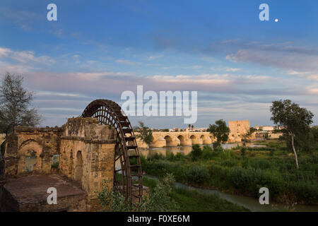 Moon at sundown over Guadalquivir River with Albolafia Waterwheel Roman Bridge and Calahorra Tower Cordoba Stock Photo