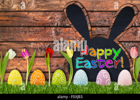 easter eggs and tulips in front of wooden background Stock Photo