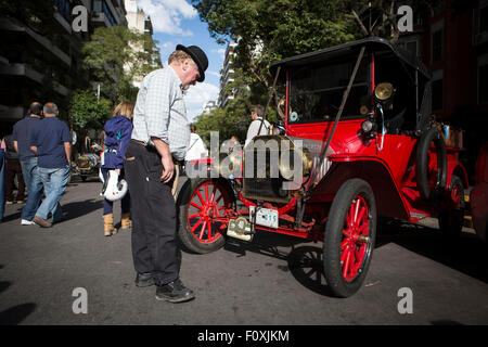 Buenos Aires, Argentina. 22nd Aug, 2015. A person watches a vehicle during an exhibition of antique automobiles, in the city of Buenos Aires, capital of Argentina, on Aug. 22, 2015. According to local press, with more than 60 cars manufactured before 1919 and organized by the Classic Car Club, the exhibition is a preview to the XIX edition of 2015 Recoleta-Tiger Grand Prix. Credit:  Martin Zabala/Xinhua/Alamy Live News Stock Photo