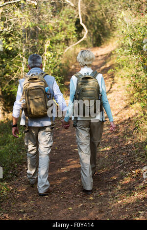 rear view of senior couple walking in forest Stock Photo