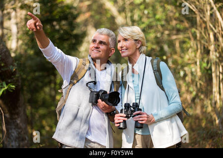 active middle aged couple hiking outdoors in forest Stock Photo