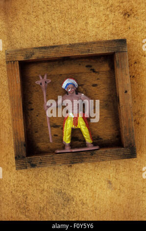 Plastic model of Native American Indian clutching totem standing with aggressive stance in wooden tray Stock Photo