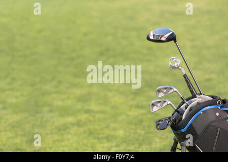 Golf and golfer concepts. A set of new golf clubs over green field background. Golf bag represented on green course. Stock Photo