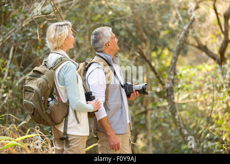 cheerful middle aged couple bird watching in forest Stock Photo