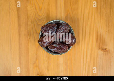 Bowl of dried dates on a wooden background Stock Photo