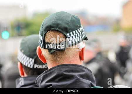Police officers stand guard at a public event, wearing baseball caps. Stock Photo