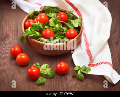 Summer salad with  lamb's lettuce and cherry tomatoes on wooden background Stock Photo