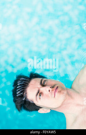 Portrait of a handsome man floating on the water surface Stock Photo