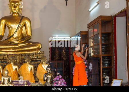 Buddhist monk taking photos in Wat Pho, Bangkok, Thailand Stock Photo