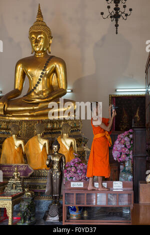 Buddhist monk taking photos in Wat Pho, Bangkok, Thailand Stock Photo