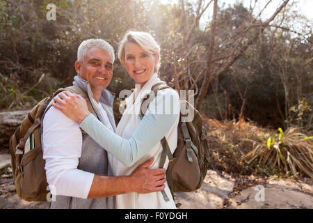 portrait of happy middle aged couple hugging in forest Stock Photo
