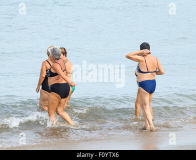 Group of pensioners morning swim following daily keep fit class on beach in Las Palmas, Gran Canaria, Canary Islands, Spain Stock Photo