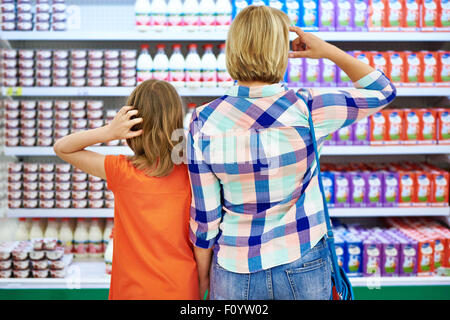 Mother and daughter choosing dairy products in shop Stock Photo