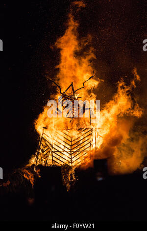 GREEN MAN, PYRE, BURNING, SET ALIGHT, TRADITION: Glanusk Park near Brecon, Wales, 23rd August 2015. The last day of The Green Man music festival in the Brecon Beacons Mountains in Wales. Overnight rainstorms turned the site into a mudbath but the sun came out in the afternoon. Pictured: The burning of the GREEN MAN (Wicker Man) on Sunday night at midnight signifies the end of the festival. Credit: Rob Watkins/Alamy Live News Team Stock Photo