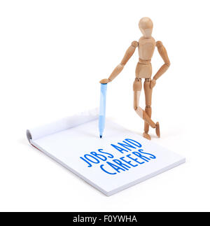 Wooden mannequin writing in a scrapbook - Jobs and careers Stock Photo