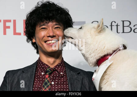 Member of Comedian Group Shinagawa Shoji, Tomoharu Shoji and SoftBank's mascot dog ''Otosan'' (father) pose for the cameras during a media event to announce a business alliance for the Netflix video delivery service in Japan on August 24, 2015, Tokyo, Japan. From September 2nd SoftBank's 37 million users will be able to access a Netflix Inc. subscription starting at 650 JPN (5.34 USD) for a Standard SD plan. The companies also plan to work on joint content creation projects. Credit:  Rodrigo Reyes Marin/AFLO/Alamy Live News Stock Photo