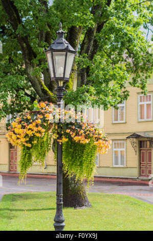 Vintage street lamp beautifully decorated with vases of fresh flowers in the city park Stock Photo