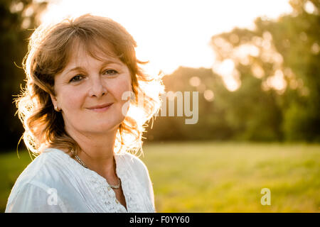 Outdoor portrait of mature woman - in nature at sunset Stock Photo