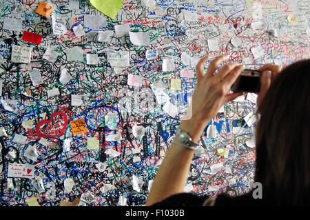 Italy, Veneto, Verona, Love notes on Juliet's House, Woman Taking Photo with Camera a Love Message at the Entrance Stock Photo