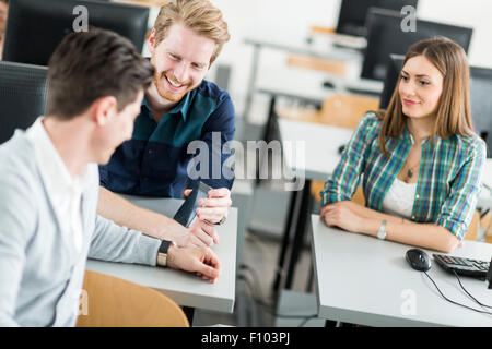 Young students talking in a classroom during break Stock Photo