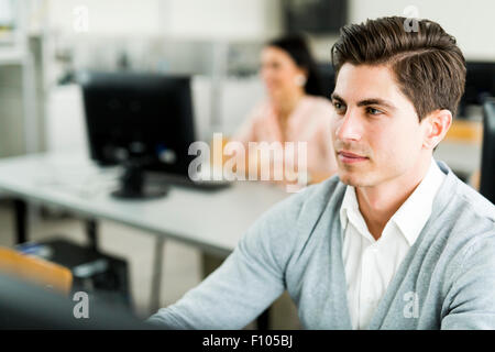 Young handsome man studying information technology in a classroom Stock Photo