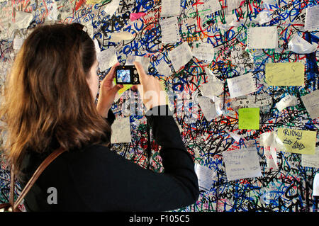 Italy, Veneto, Verona, Love notes on Juliet's House, Woman Taking Photo with Camera a Love Message at the Entrance. Stock Photo
