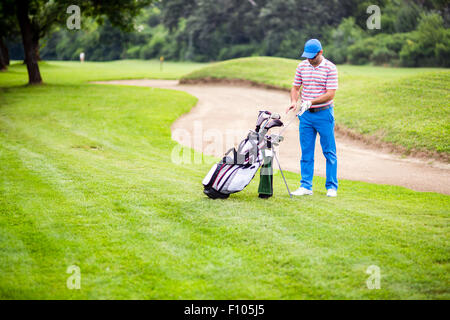 Golfer selecting appropriate club for the next shot Stock Photo