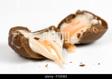 Cadbury creme egg oozing out onto a white background Stock Photo