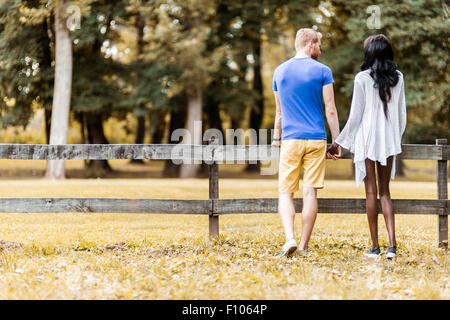 Happy couple in love holding hands in a park in autumn Stock Photo